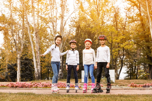 Preview: Happy children wearing roller skates in autumn park