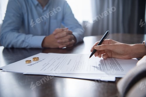 Preview: partial view of couple at table with divorce documents