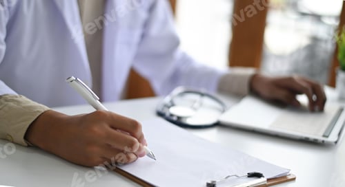 Preview: Doctor wearing a lab gown recording the results of auscultation on a clipboard and laptop.