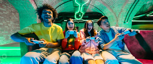 Preview: Multiethnic group of young friends playing videogames at home