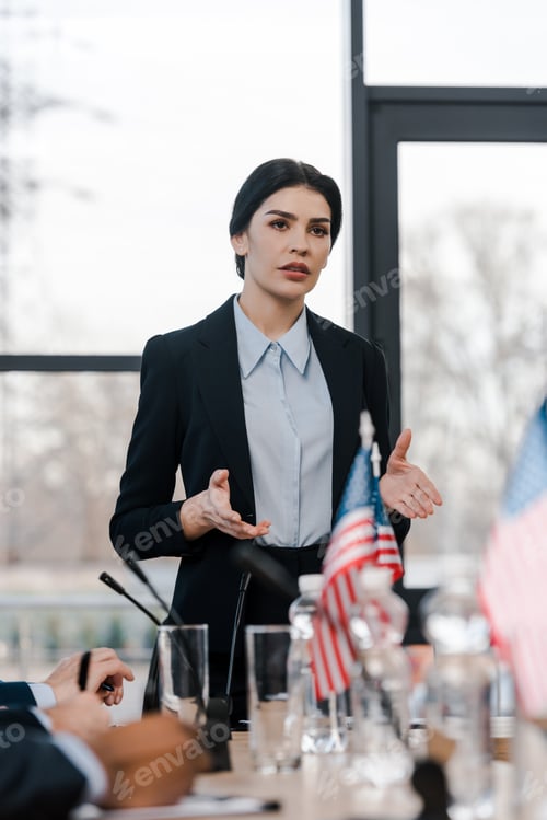 Preview: selective focus of attractive speaker talking near multicultural diplomats