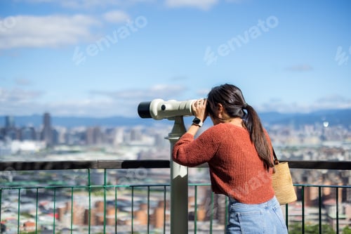 Preview: Tourist woman look at the binocular in the city