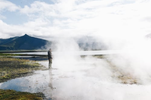 Preview: Man stand over geyser lake in iceland