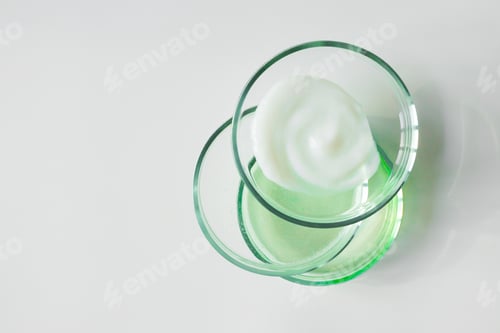 Preview: Glass petri dishes with various cosmetic products on white background