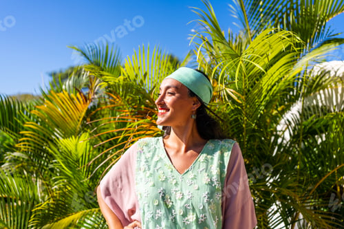 Preview: Smiling model wearing a headband and a long dress outdoors