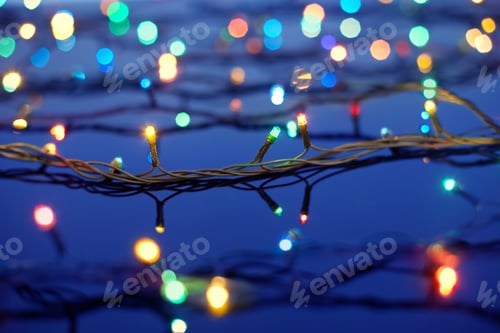 Preview: Christmas lights on dark blue background with copy space. Decorative garland