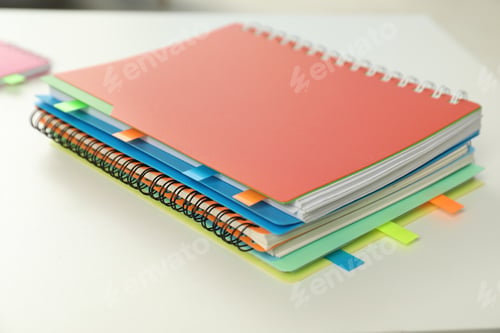 Preview: Notebooks with colorful tabs on light table, closeup