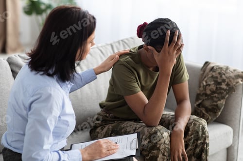 Preview: Female Psychologist Comforting Black Soldier Lady During Therapy Session In Office