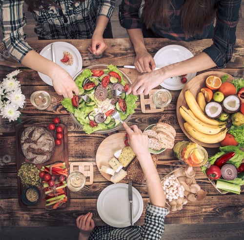 Preview: Enjoying dinner with friends. Top view of group of people having dinner together