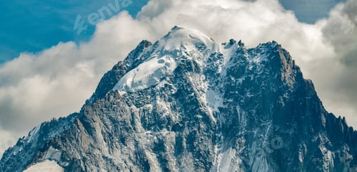 Preview: Aiguille Verte in close-up with snow topped mountain and clouds in the background