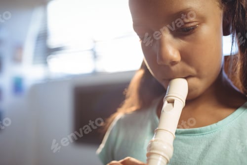 Preview: Thoughtful girl playing flute in classroom