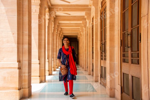 Preview: Young female tourist walking between arches and Pillars.