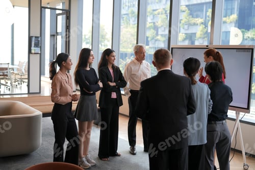 Preview: Diverse business team collaborating on a project in a modern office with large windows