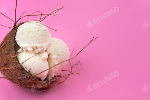 Preview: Vanilla ice cream balls in an empty coconut decorated with mint leaves on a pink background