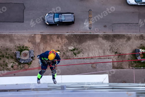 Preview: Top view of professional industrial mountaineering worker washing facade