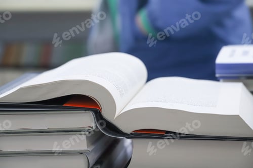Preview: Open book on table with blur bookshelf background