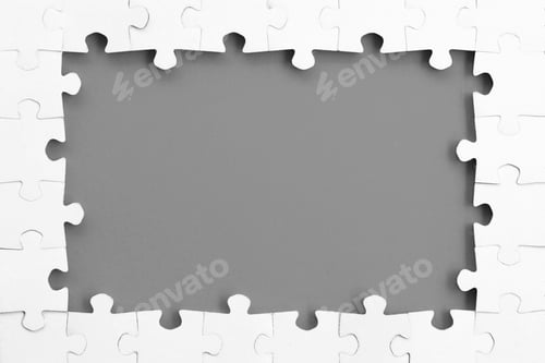 Preview: White jigsaw puzzle pieces connected to create frame on gray background, copy space, text overlay