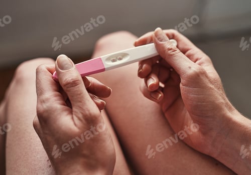Preview: Cropped shot of an unrecognizable young woman looking at her pregnancy test results at home
