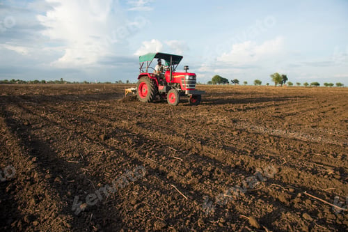 Preview: farmer with tractor preparing land for sowing with cultivator