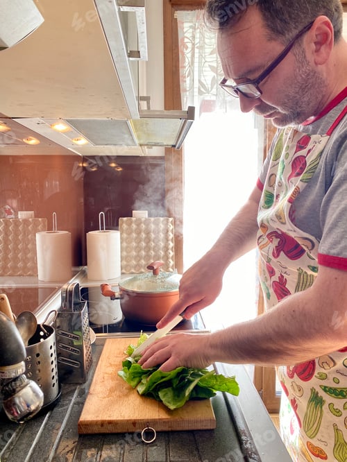 Preview: Middle aged man cooking at home,