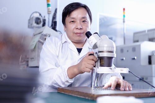 Preview: Technician with microscope in LED factory