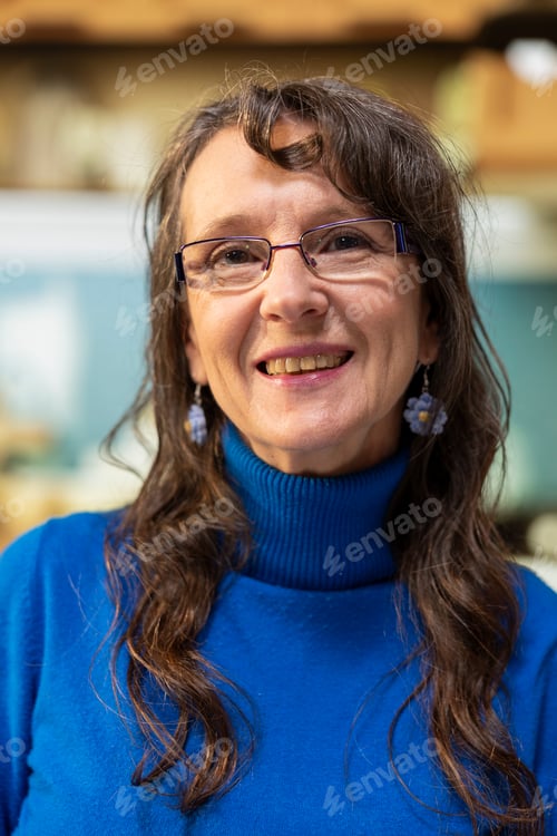 Preview: Portrait of senior woman smiling in the kitchen and enjoying cup of warm drink