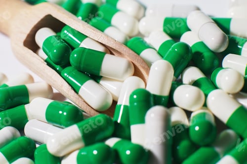 Preview: medicine green pills on white background on a wooden spoon. sorted pharmaceutical