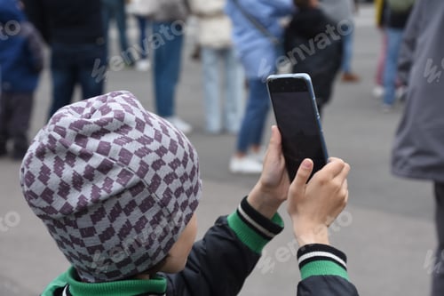 Preview: Caucasian Schoolerboy using modern technology and takes video for his friends on mobile phone