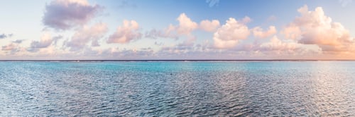 Preview: Dramatic clouds at sunset, with a cloudscape over a horizon of the blue waters of the Pacific Ocean,