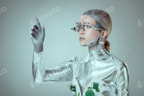 Preview: futuristic silver robot gesturing with hand and looking away isolated on grey, future technology