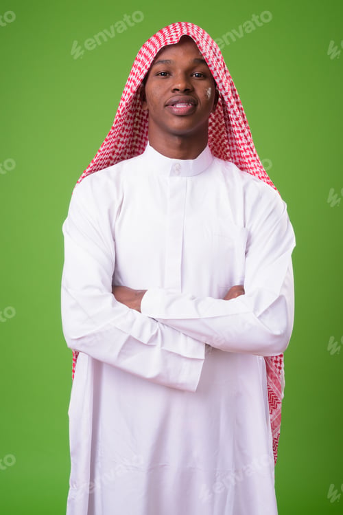 Preview: Young African man wearing traditional Muslim clothes against gre