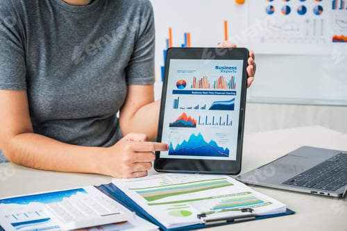 Preview: businesswoman works diligently at her desk, reviewing financial documents and analyzing investment