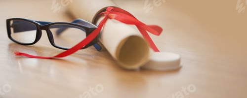 Preview: The world awaits. Shot of a pair of glasses next to a diploma.