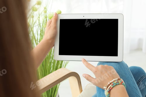 Preview: Woman holding tablet with blank screen indoors. Mockup for design