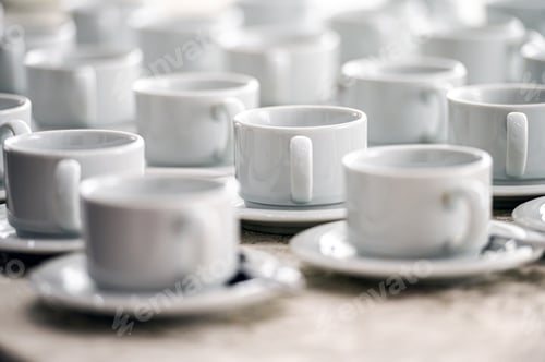 Preview: a lot of rows of pure white cups with plates for coffee or tea break