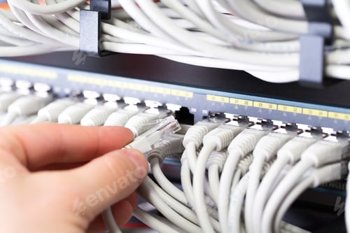 Preview: IT consultant connects a network cable into switch in datacenter
