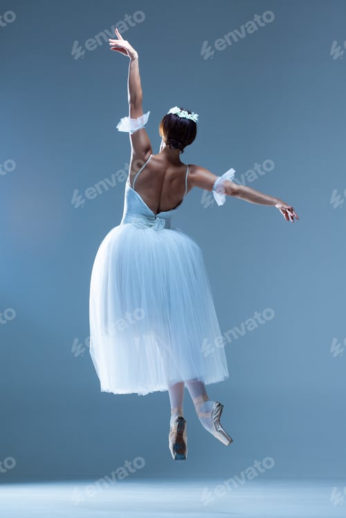 Preview: Portrait Of The Jumping Classical Ballerina In White Dress On Blue Background