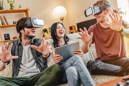 Preview: young friends having fun with VR googles while their female friend using digital tablet at home
