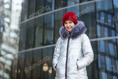 Preview: woman in a warm jacket on the street near the building