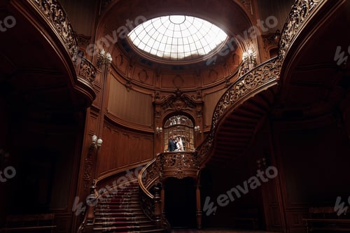 Preview: Elegant gorgeous bride and stylish groom standing on wooden stairs in rich room