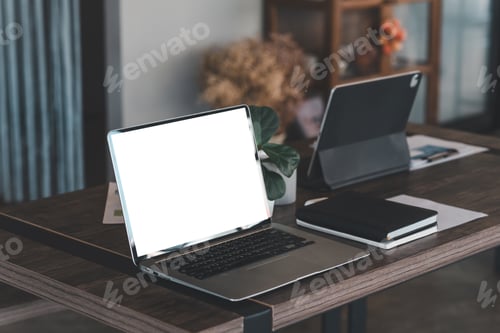 Preview: Mockup. Laptop white blank screen and papers at the wooden table at the office.