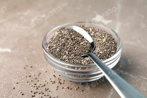 Preview: Glass sauce boat with chia and spoon on textured background, close up