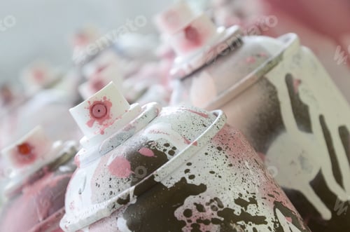 Preview: A lot of dirty and used aerosol cans of bright pink paint. Macro photograph with shallow