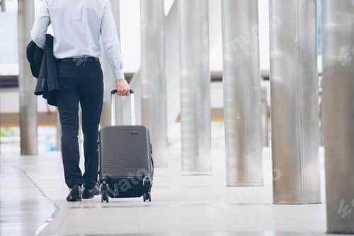 Preview: Businessman Dragging suitcase luggage, walking to passenger boarding area in Airport.