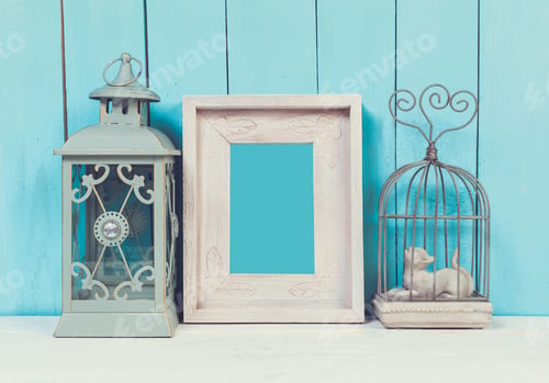 Preview: Stylish vintage decor arrangement featuring lantern, picture frame, and wire cage