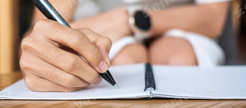 Preview: Young Businesswoman writing something on notebook in office or cafe