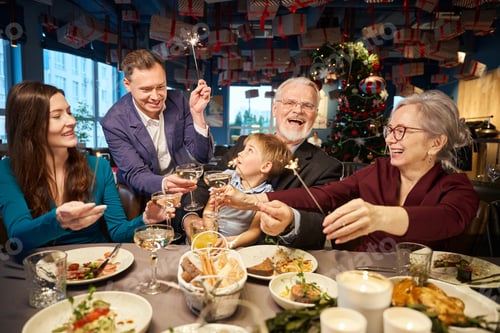Preview: Family with Bengal lights clinking champagne glasses celebrating New Year