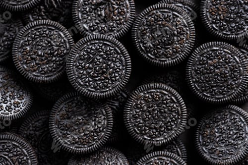 Preview: Textured dark background with circle shape cookies black color. Unhealthy junk dessert food