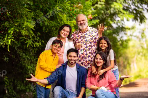 Preview: Indian family bonding happily while standing outdoors and smiling together
