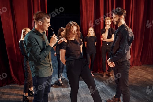 Preview: Eye contact practice. Group of actors in dark colored clothes on rehearsal in the theater